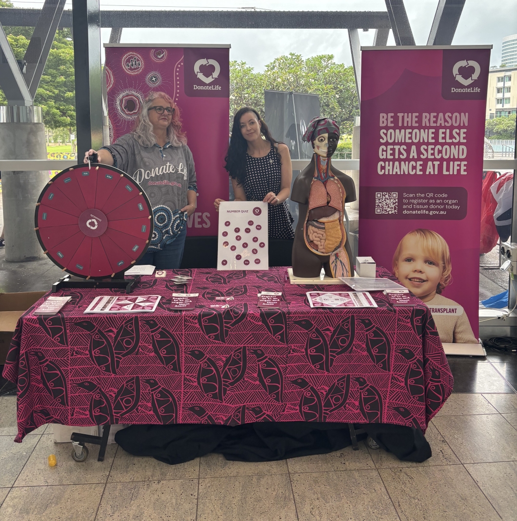 An organ and tissue donation awareness booth featuring a colorful wheel, informative materials, and a life-sized model displaying organs.