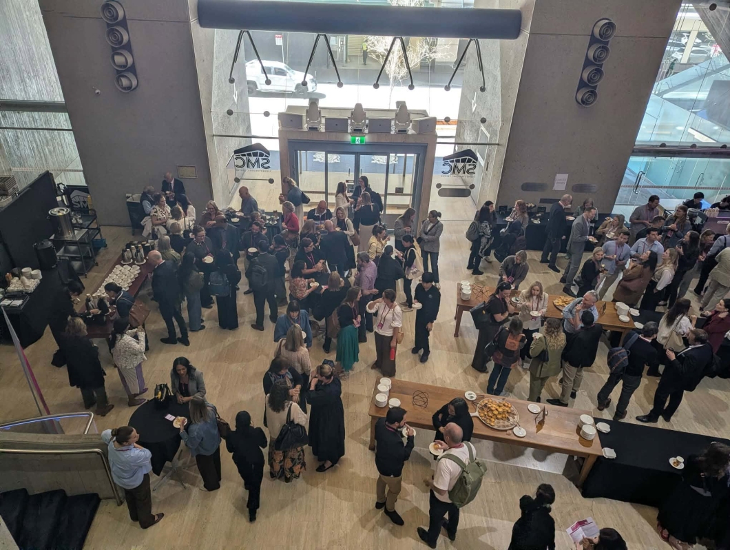 Delegates gather in a large conference foyer during a networking break at the 2026 DonateLife Symposium, speaking in small groups around refreshment tables.
