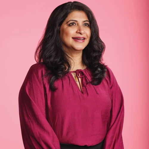 Manisha pictured in front of a pink backdrop