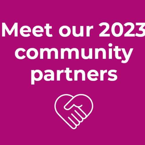 Magenta background with white text saying Meet our 2023 community partners. White heart logo with hands interlocking