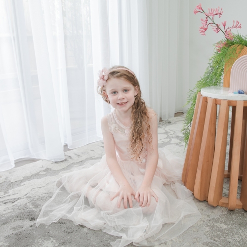 Photo of tissue recipient Madison, sitting on grey carpet wearing a pink tutu dress and pink headband