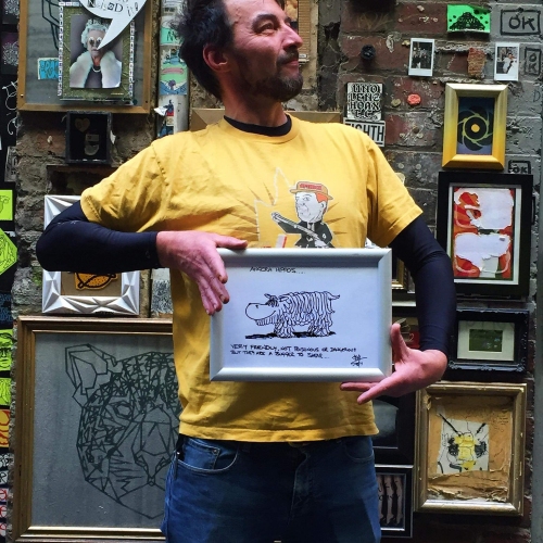Sime holding up his cartoon art