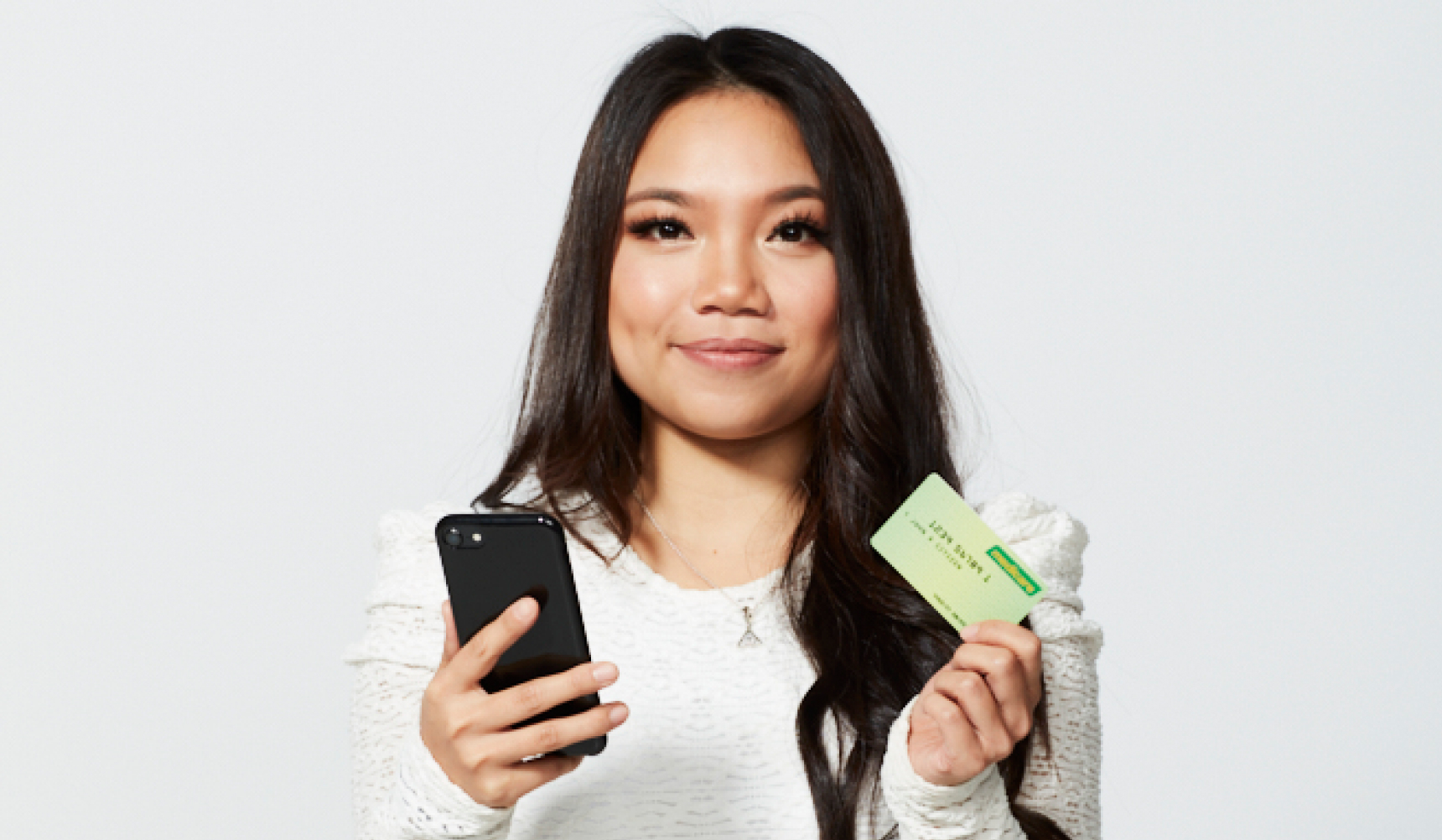 Kidney Recipient Kristy holding her mobile phone and medicare card